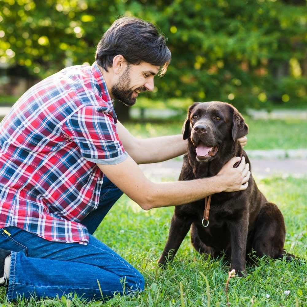 man-patting-his-dog-park_23-2147902254